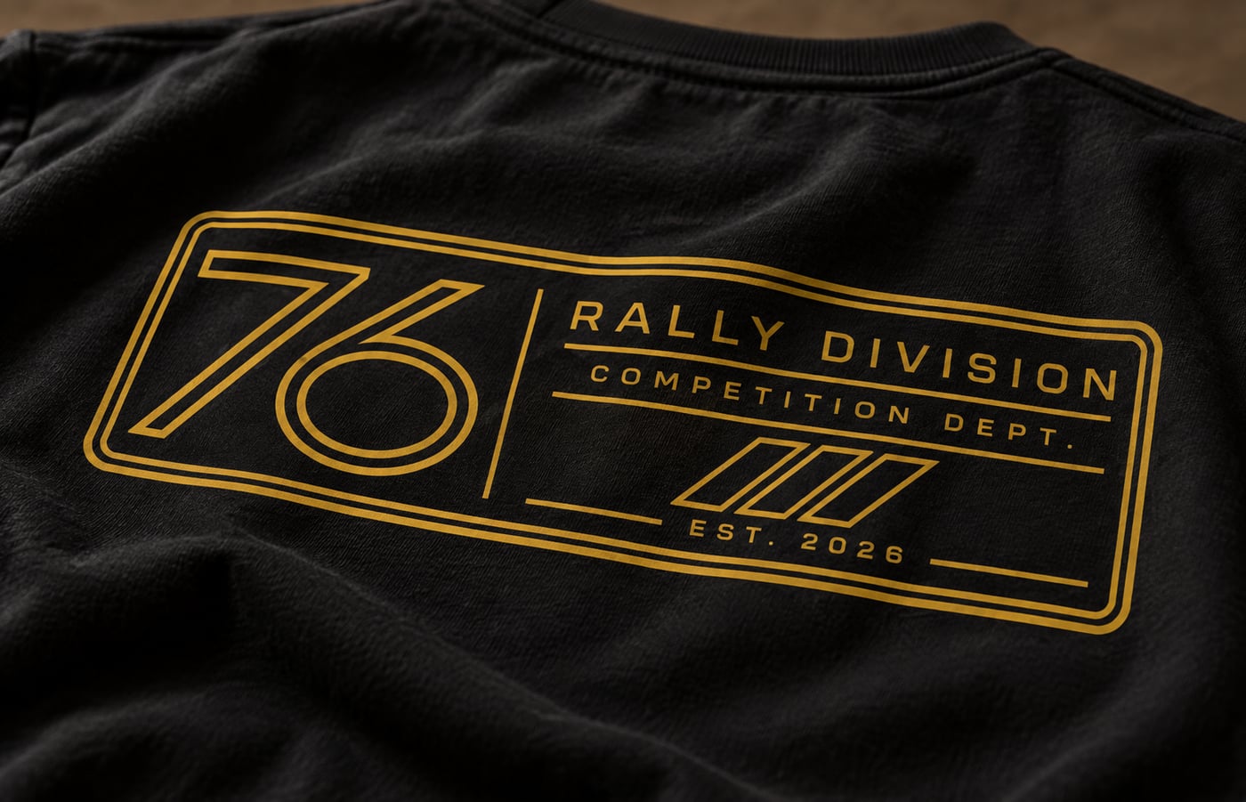 A close-up of the gold 76 Rally Division graphic on black apparel